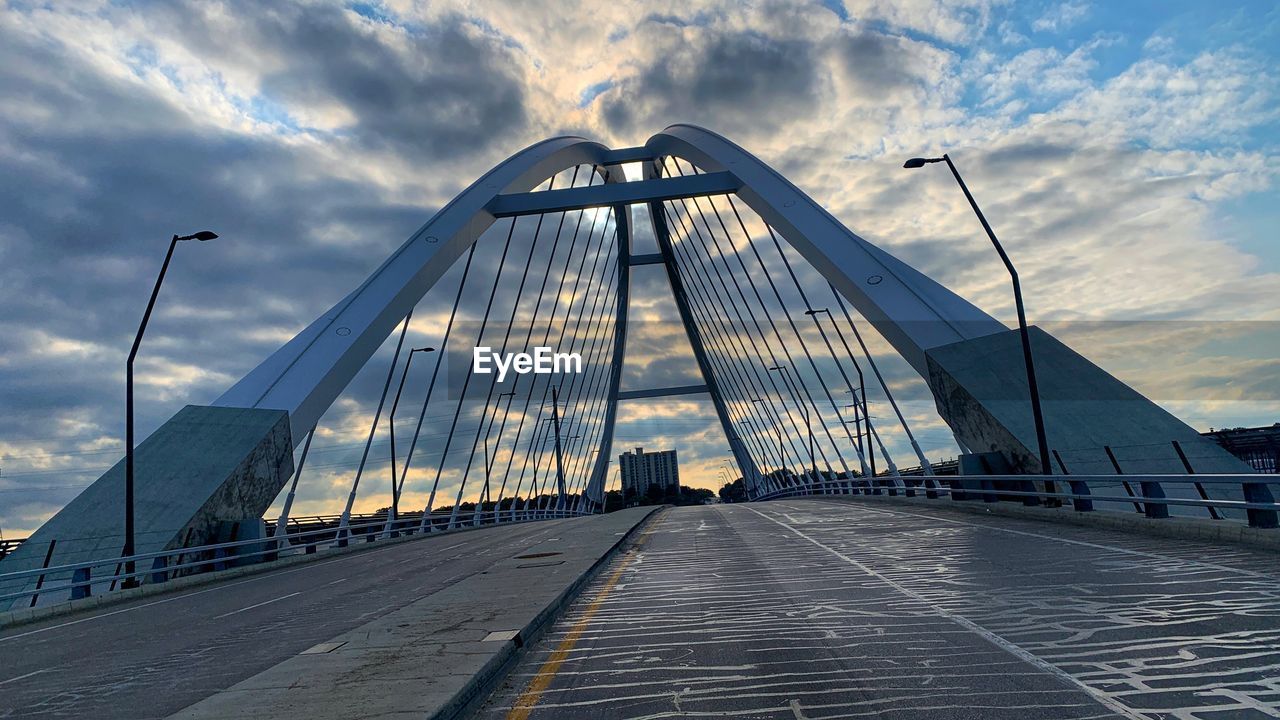 architecture, sky, bridge, cloud, transportation, built structure, cable-stayed bridge, city, nature, landmark, travel destinations, travel, road, the way forward, suspension bridge, no people, sunlight, outdoors, building exterior, blue, tourism, water, landscape, street, sunset, horizon, cityscape, environment