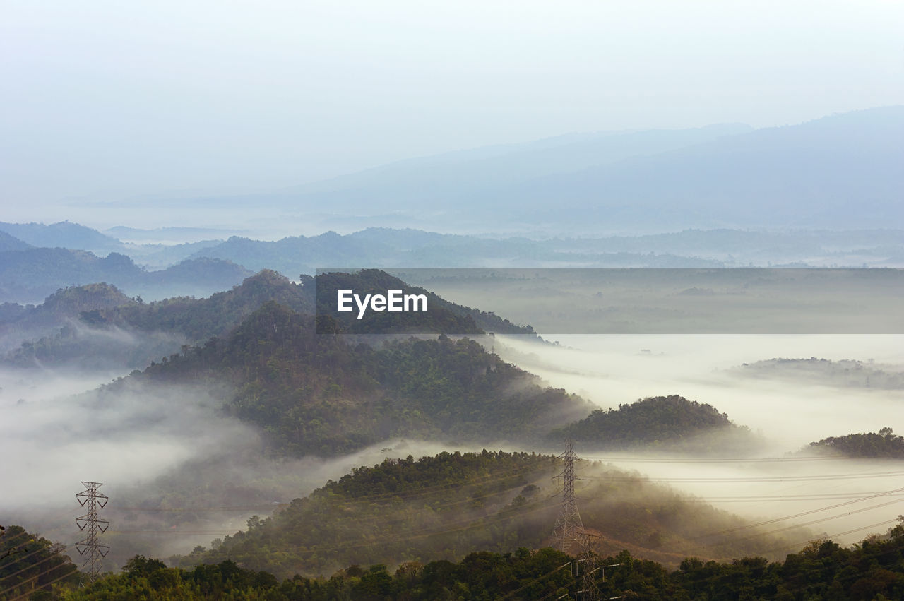 Fog on mountain mae moh lampang with high voltage power transmission towers.