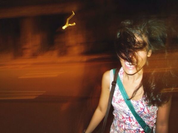 Blurred motion of woman laughing by street