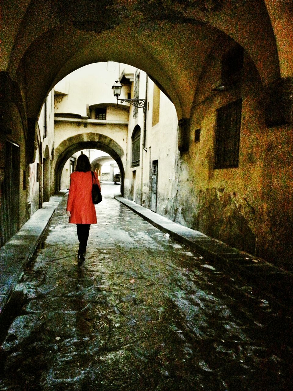 Rear view of woman walking at archway