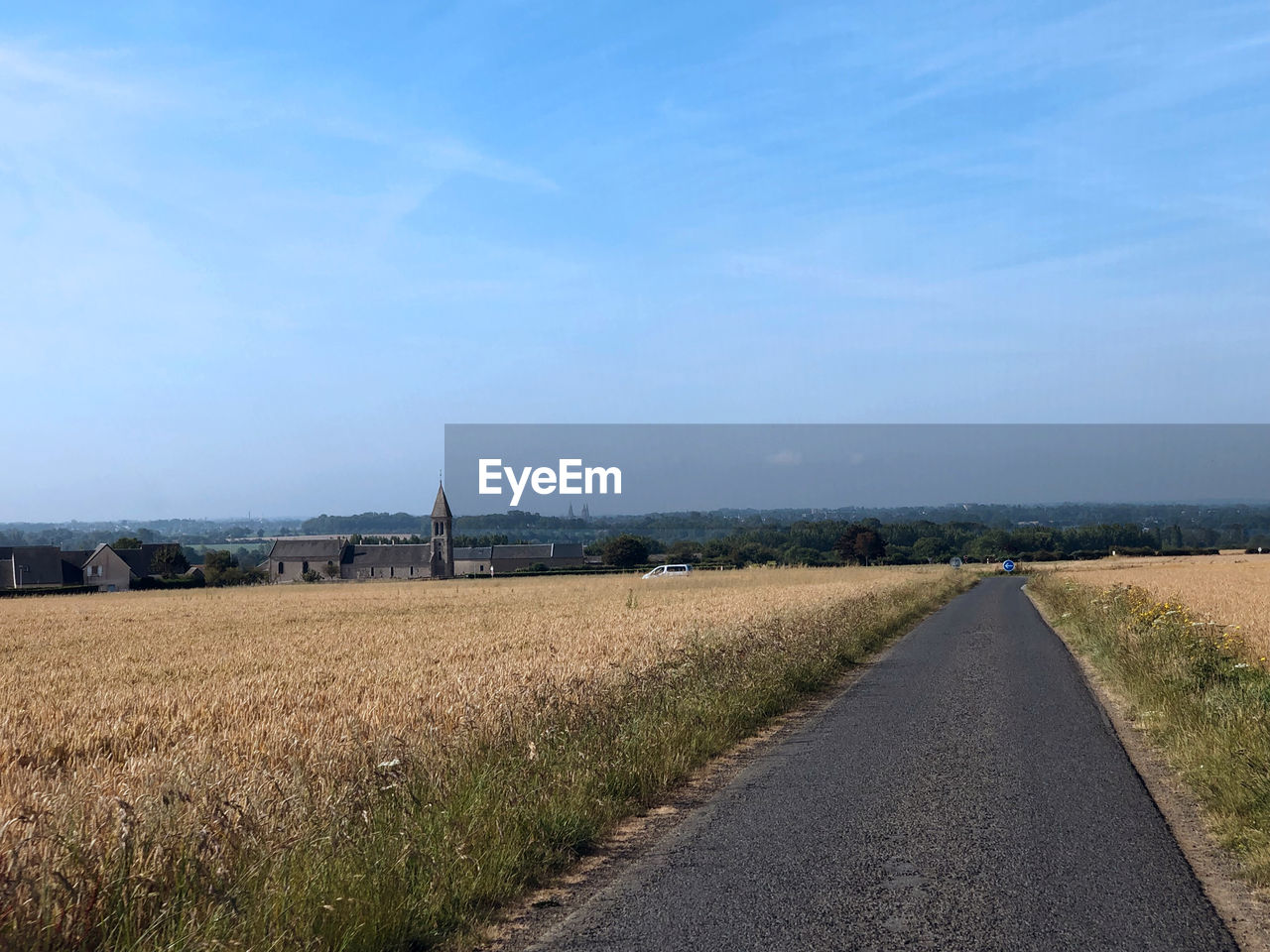 ROAD BY AGRICULTURAL FIELD AGAINST SKY