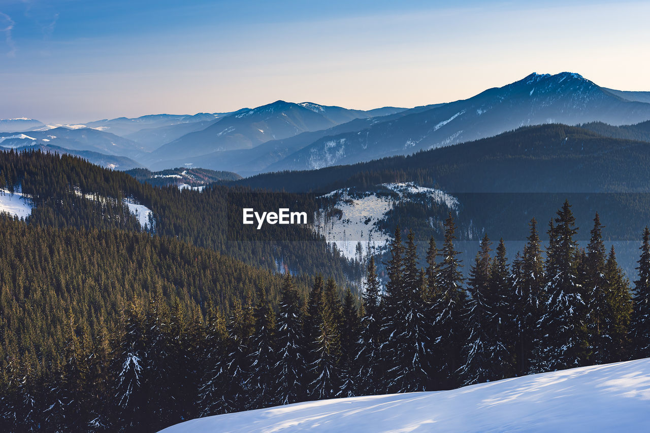 Scenic view of snow covered mountains against sky