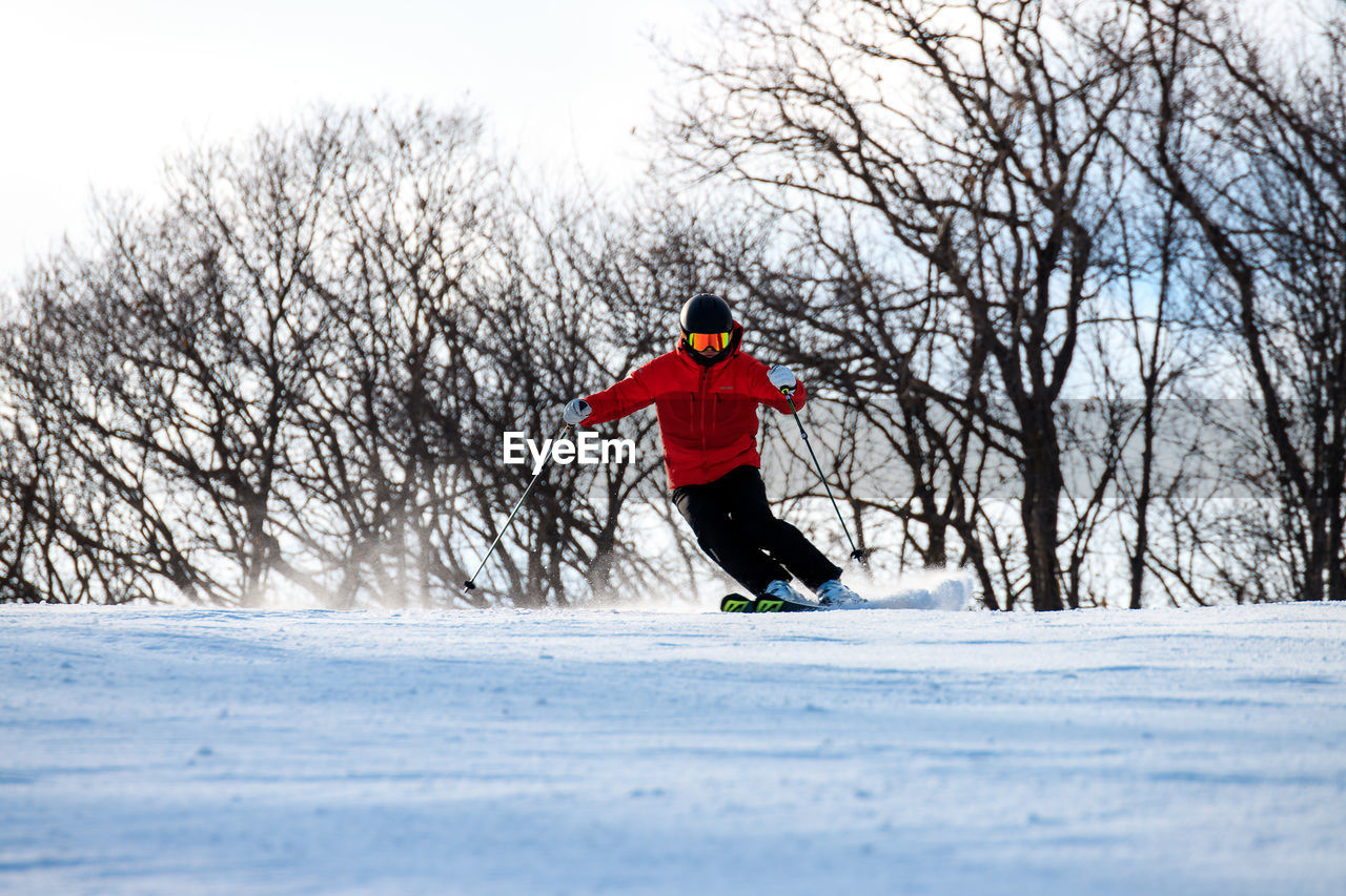 FULL LENGTH OF MAN WITH UMBRELLA ON SNOW