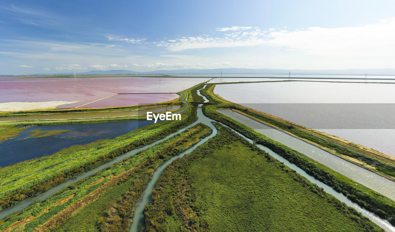 Multi colored water in ponds and stream in salt marsh in sf bay aerial