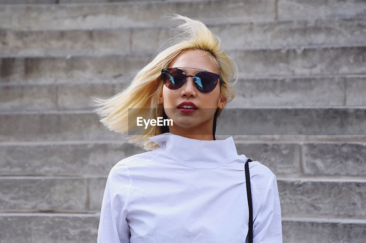 PORTRAIT OF BEAUTIFUL YOUNG WOMAN WEARING SUNGLASSES