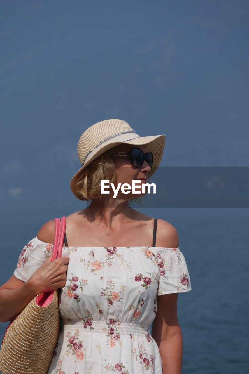 Mature woman standing by sea