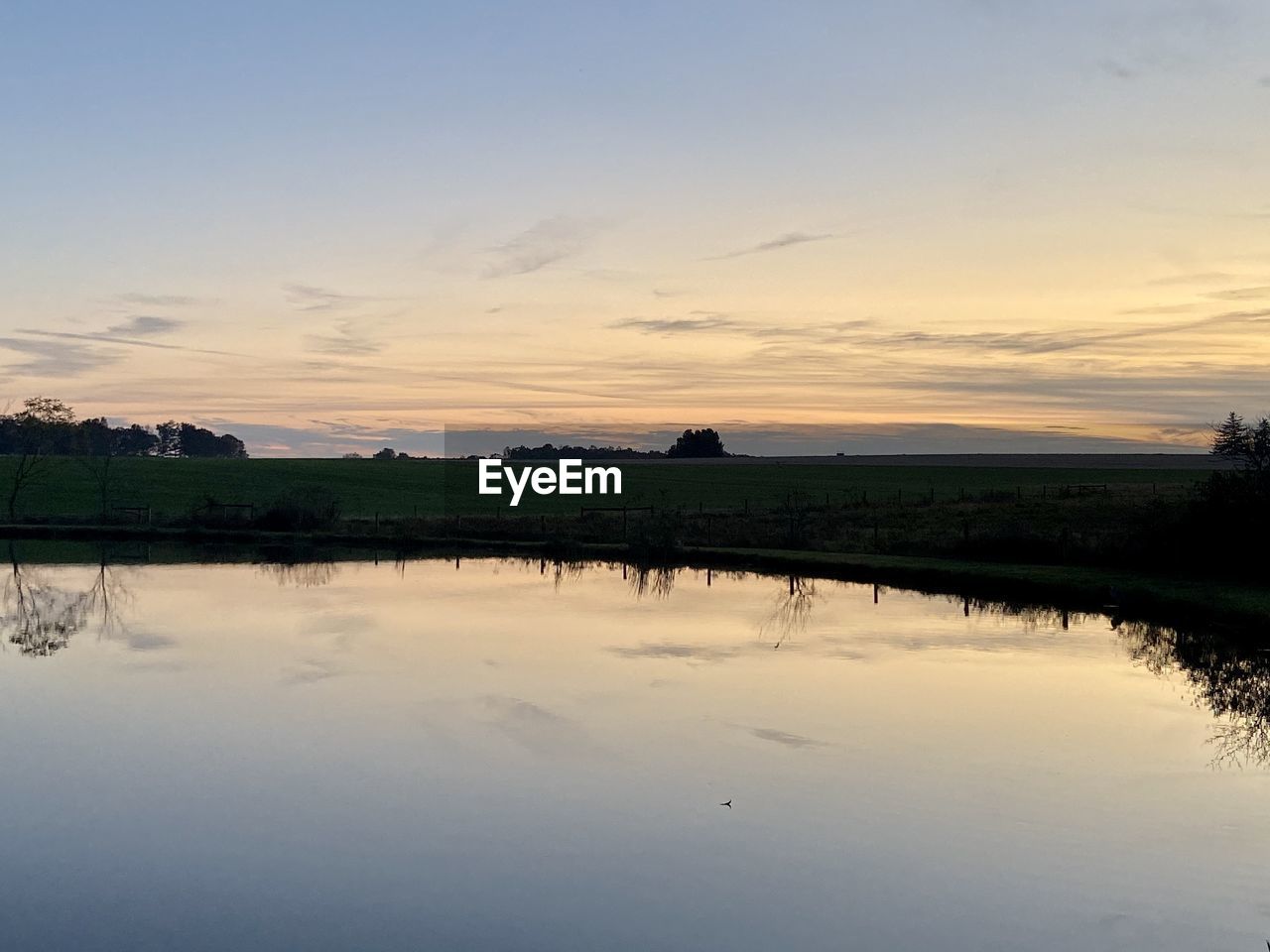 SCENIC VIEW OF LAKE AGAINST ORANGE SKY