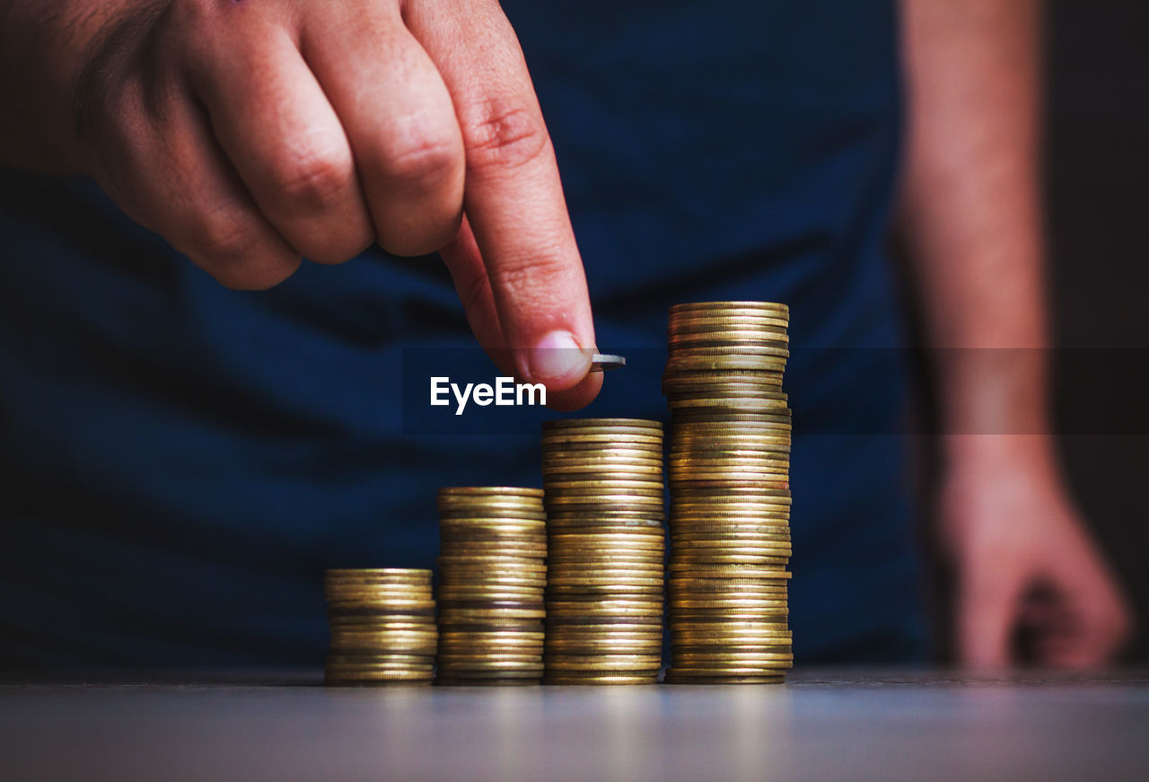 Cropped image of hand holding stack of coins