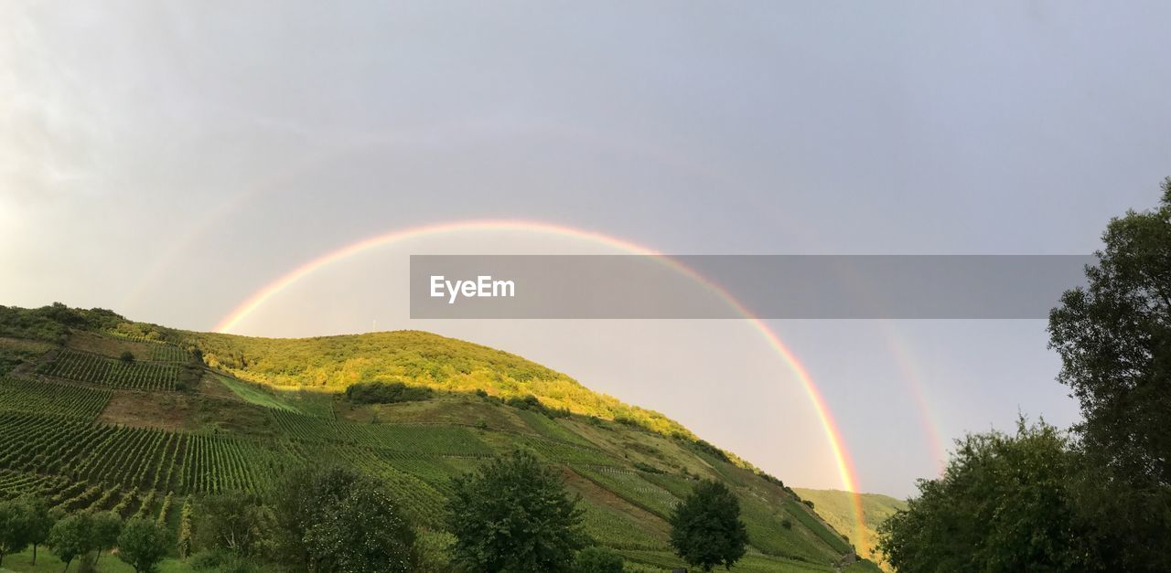 Rainbow over landscape against sky