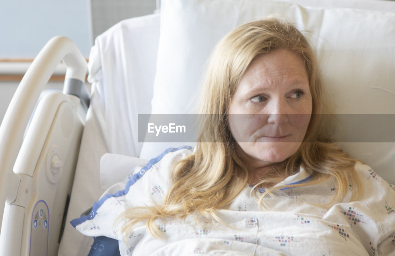 Mature woman lying on bed in hospital