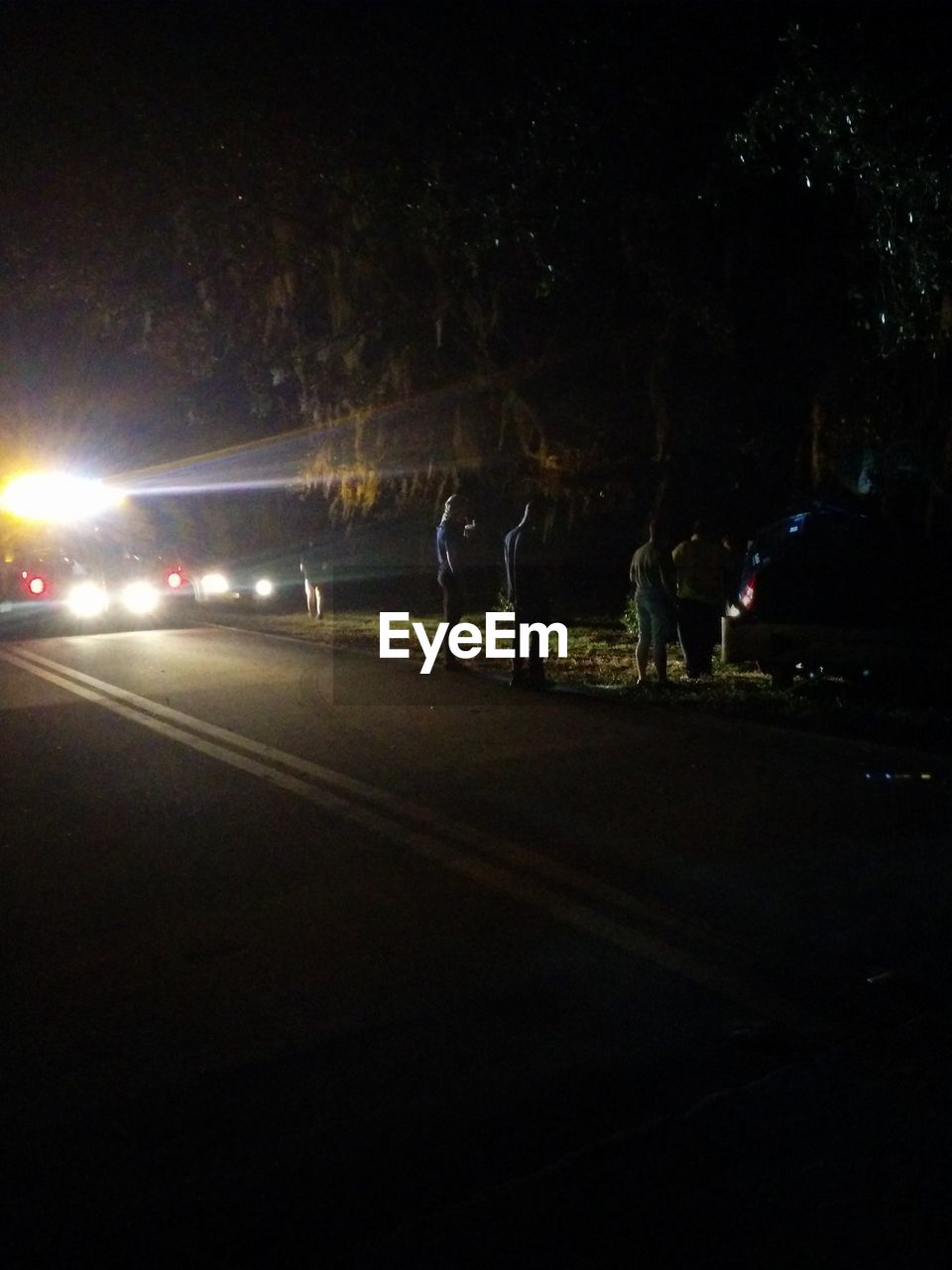 BLURRED MOTION OF PEOPLE WALKING ON ROAD AT NIGHT