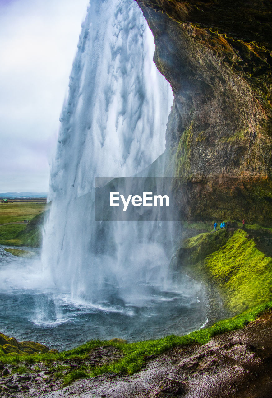 SCENIC VIEW OF WATERFALL AGAINST ROCKS