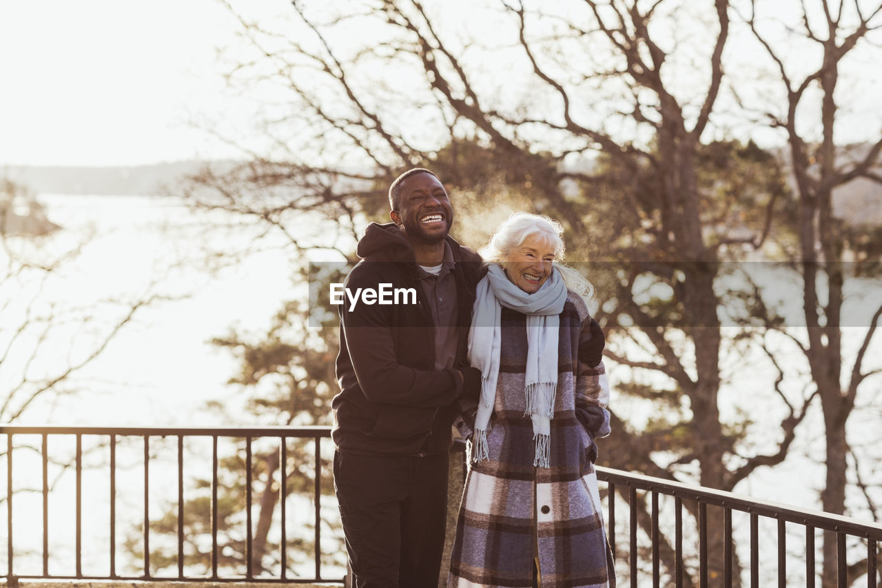 Happy male healthcare worker and elderly woman standing in park