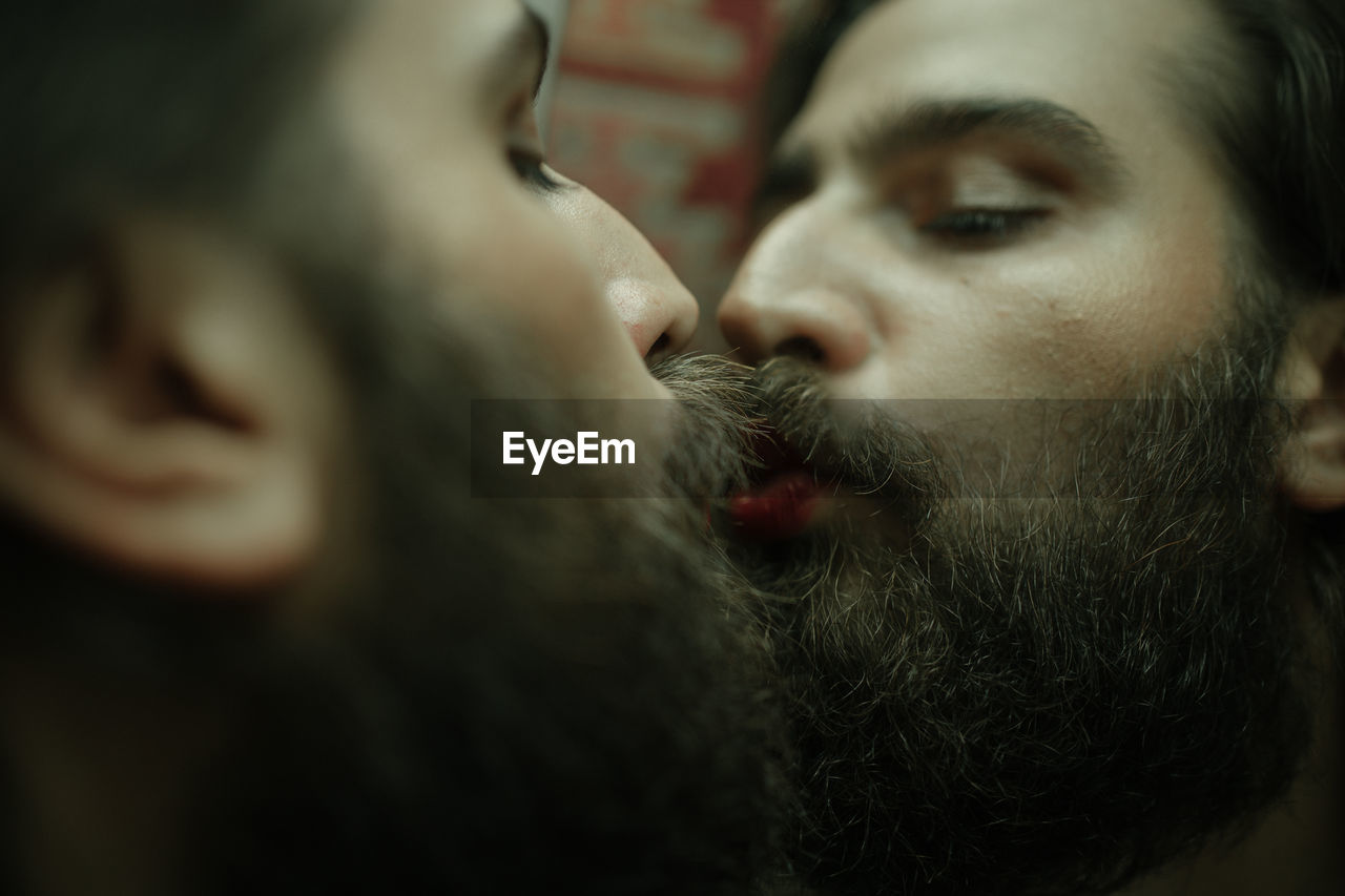 Close-up of bearded man kissing on mirror