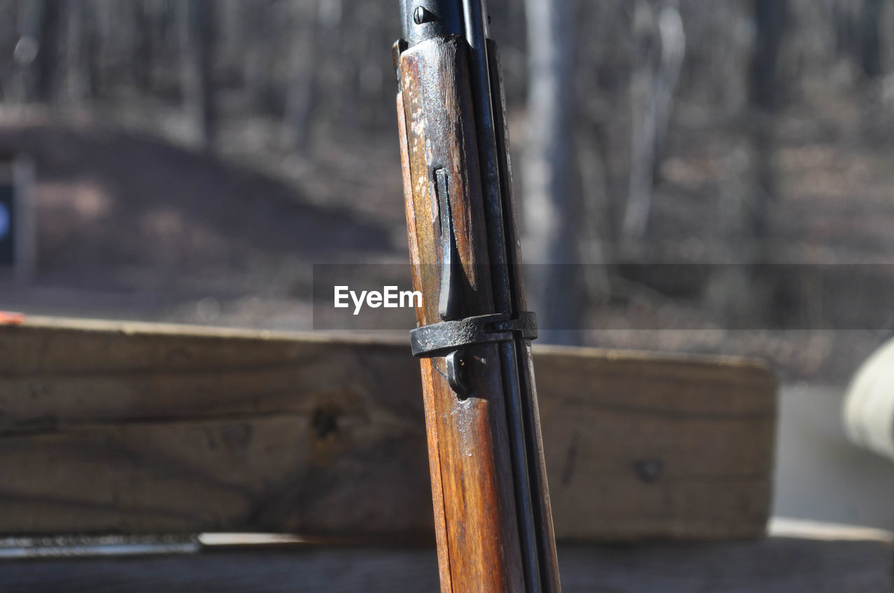 Close-up of gun against railing