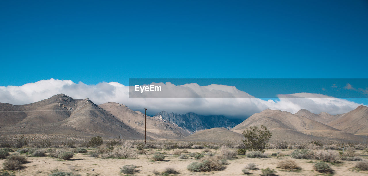 Scenic view of mountains against blue sky