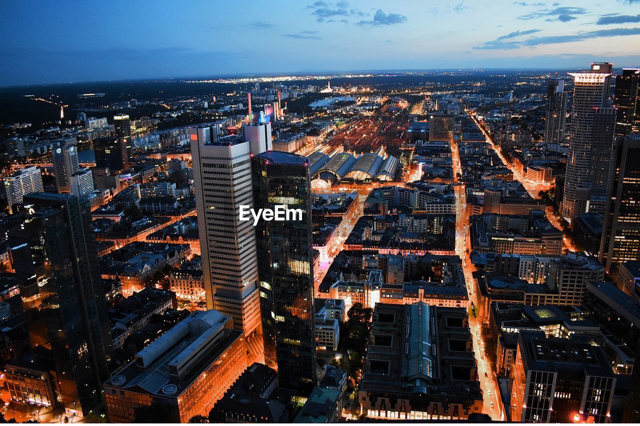 High angle view of illuminated buildings against sky at dusk