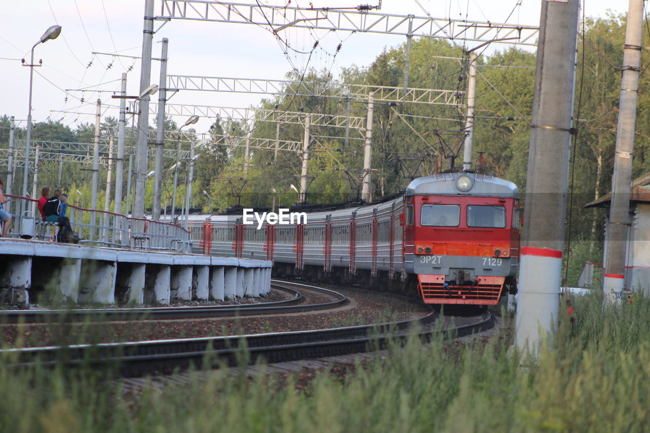 Train by railroad tracks against sky