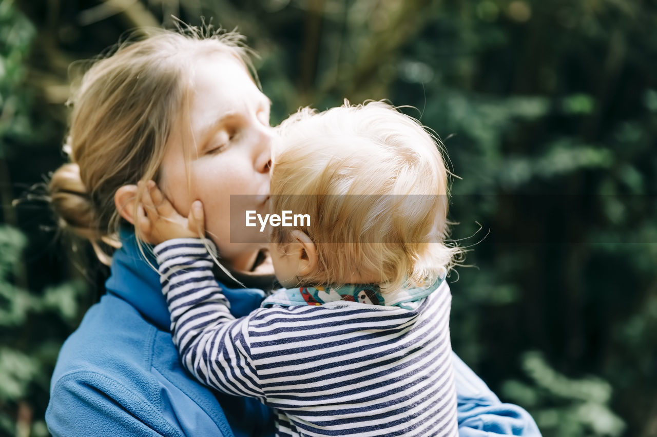 Close-up of mother kissing son