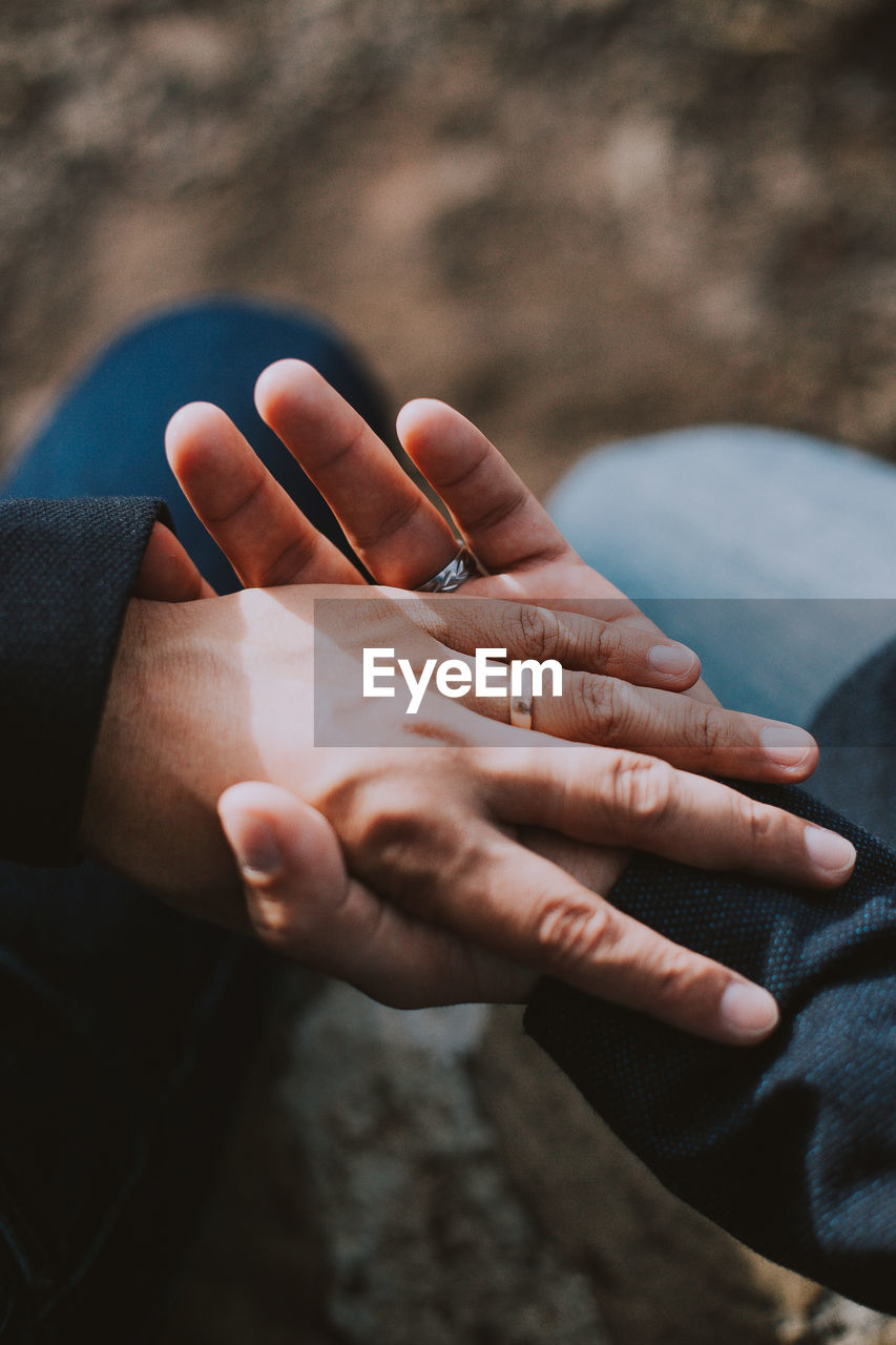 Cropped image of couple holding hands outdoors