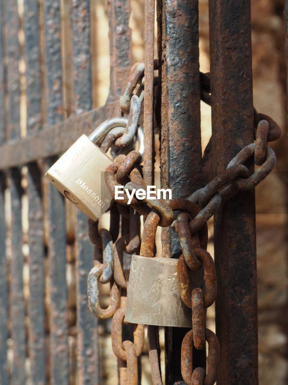 CLOSE-UP OF RUSTY PADLOCK ON METAL GATE