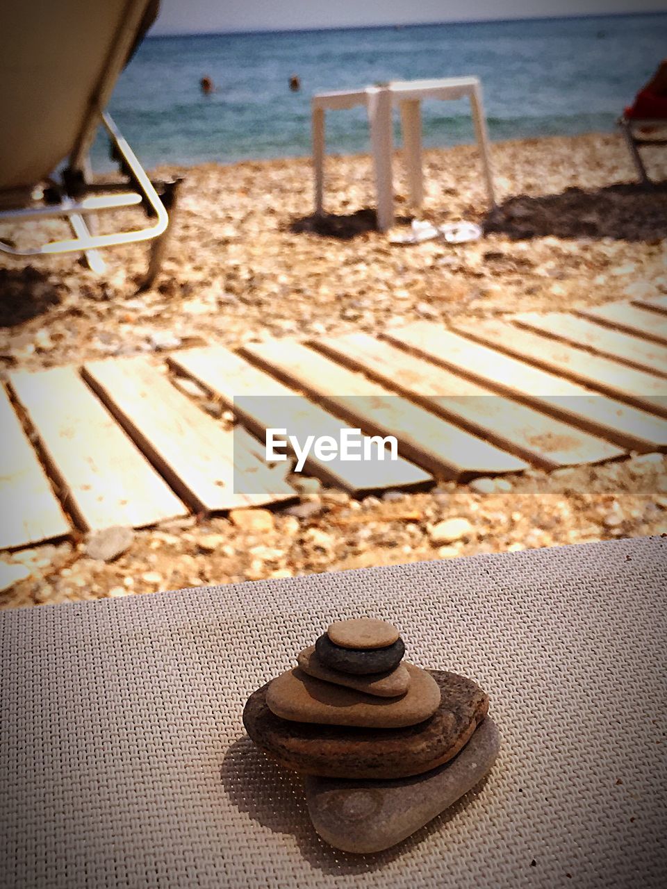 High angle view of stone stack on chair at beach