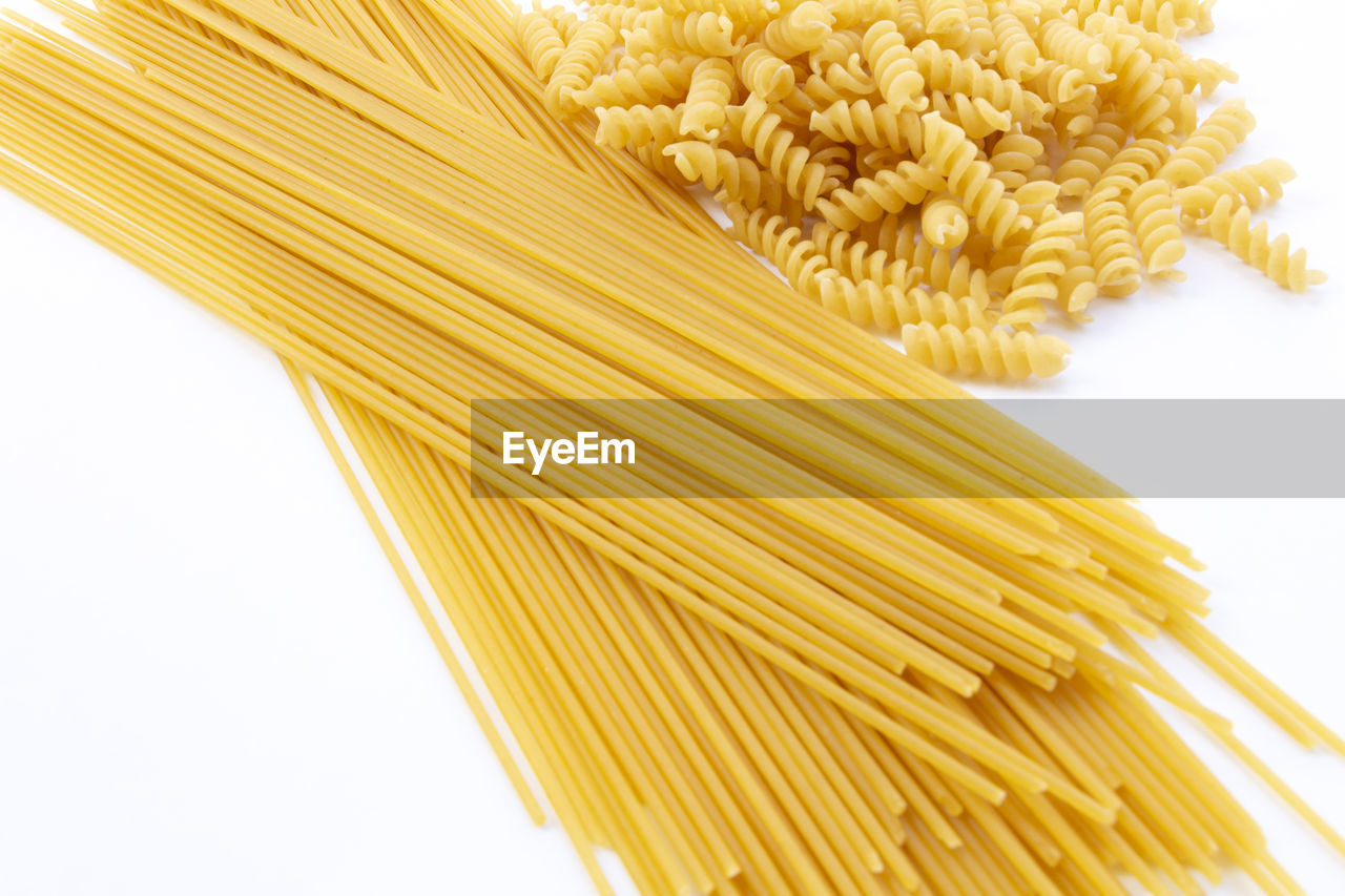 pasta, food, italian food, food and drink, raw food, spaghetti, freshness, wellbeing, healthy eating, indoors, yellow, cereal plant, crop, cut out, plant, cuisine, white background, studio shot, close-up, ingredient, agriculture, corn, whole wheat, wheat, dish, food grain, no people, vegetable, whole grain, dry, produce, still life, vegetarian food, large group of objects