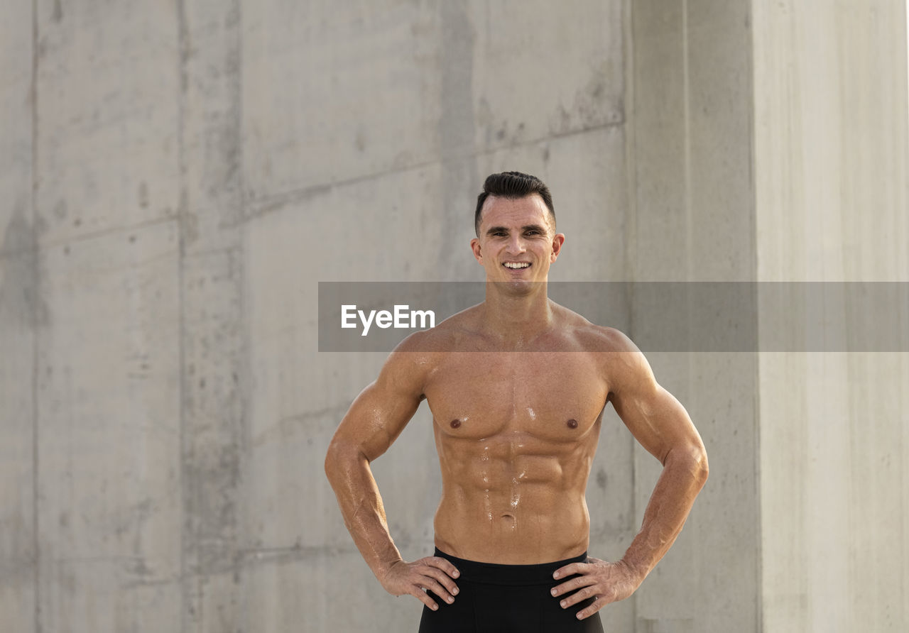 Muscular shirtless man standing outdoors
