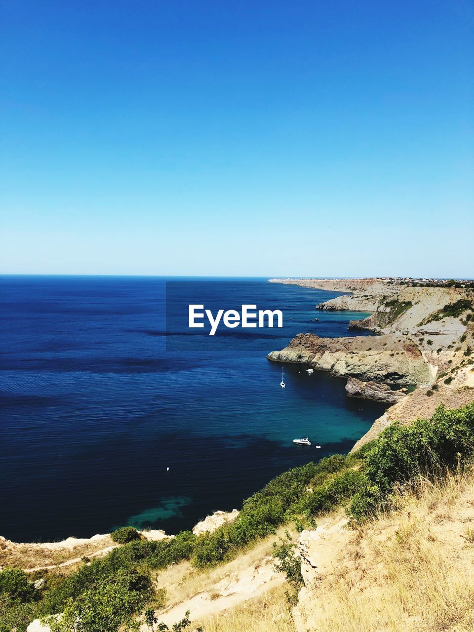 Scenic view of sea against clear blue sky