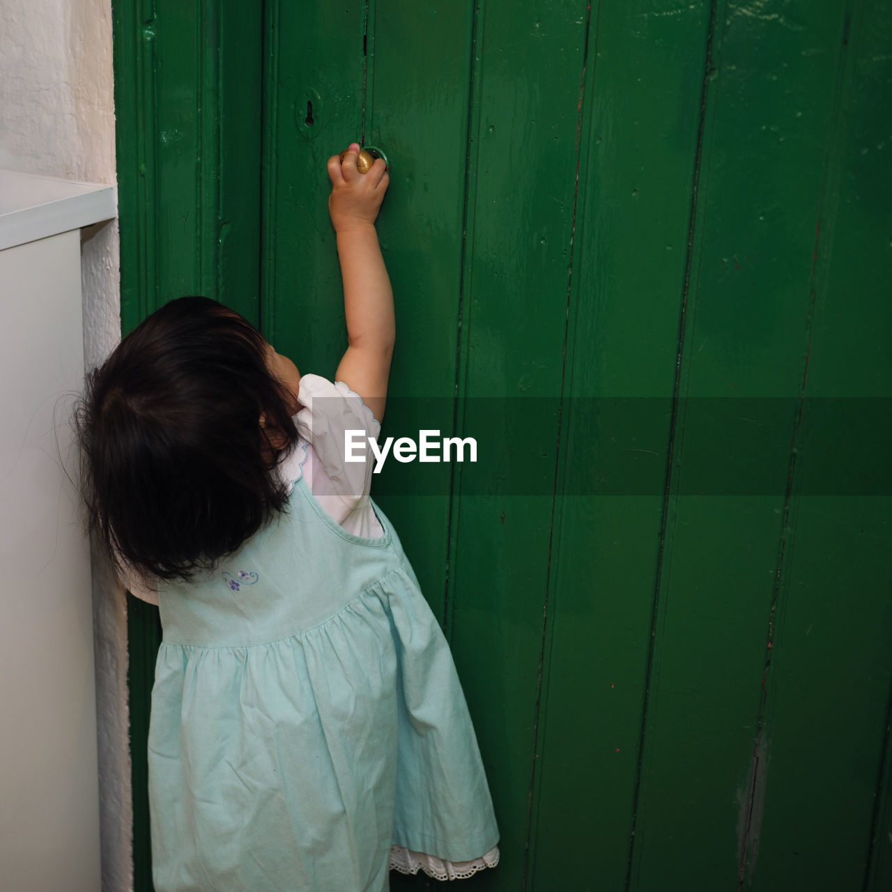 Rear view of girl standing by door