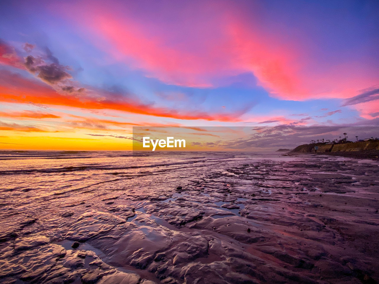 Scenic view of sea against dramatic sky during sunset