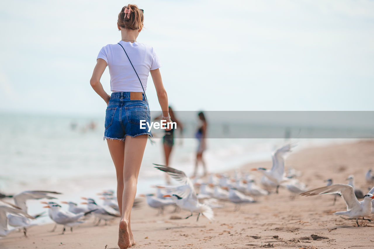 rear view of woman standing on beach