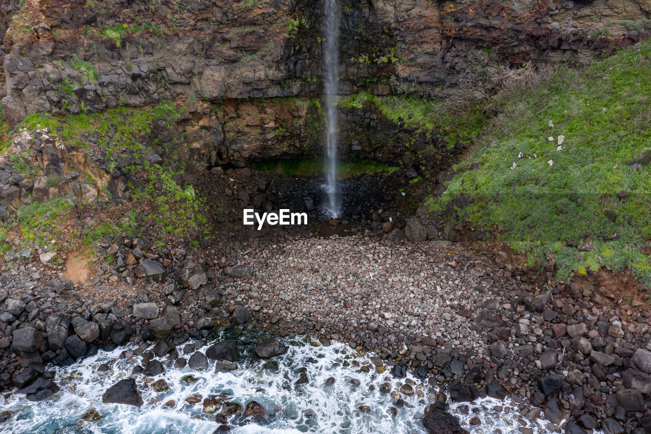 WATER FLOWING THROUGH ROCKS IN STREAM