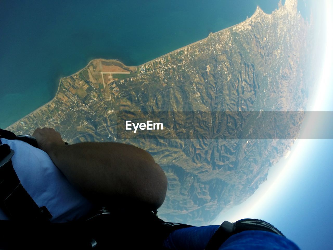 LOW SECTION OF PERSON ON SNOWCAPPED MOUNTAINS AGAINST SKY