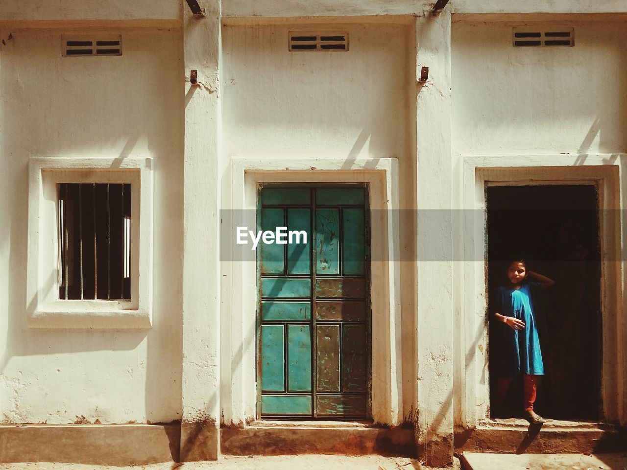 Girl standing on doorway of house