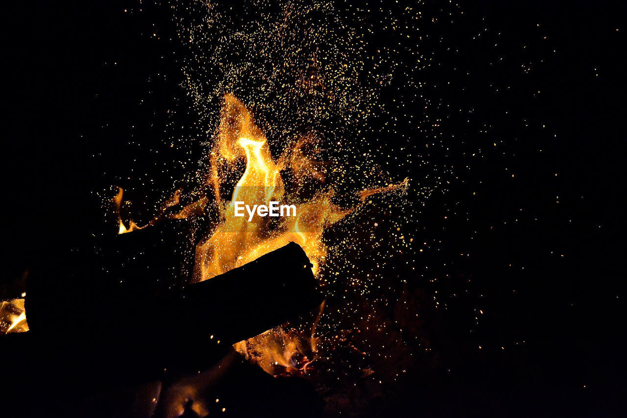 Close-up of firewood burning at night