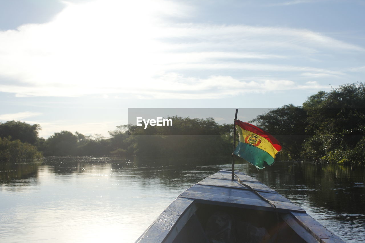 Bolivian flag on boat at lake against sky