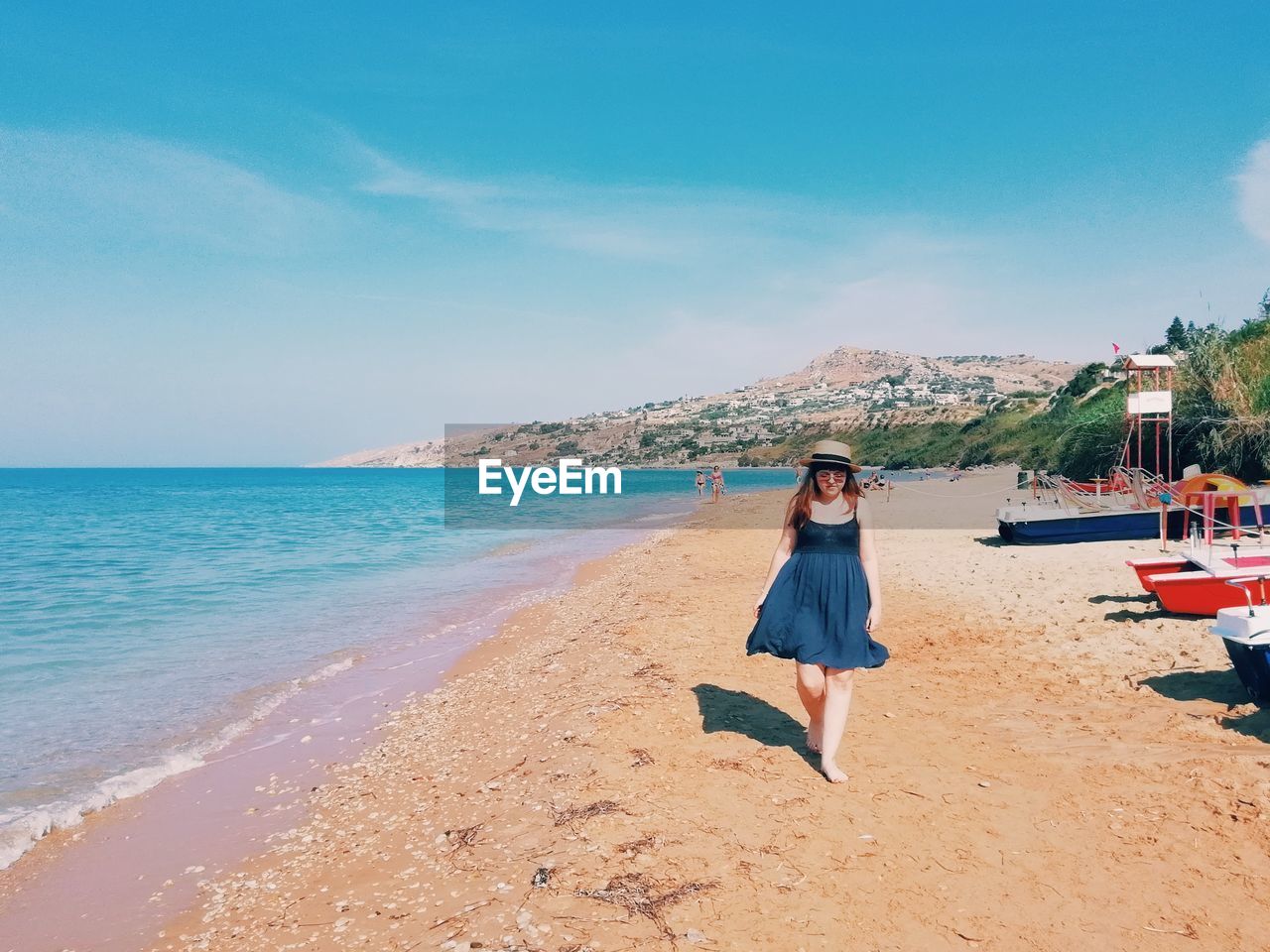 WOMAN ON BEACH AGAINST SKY