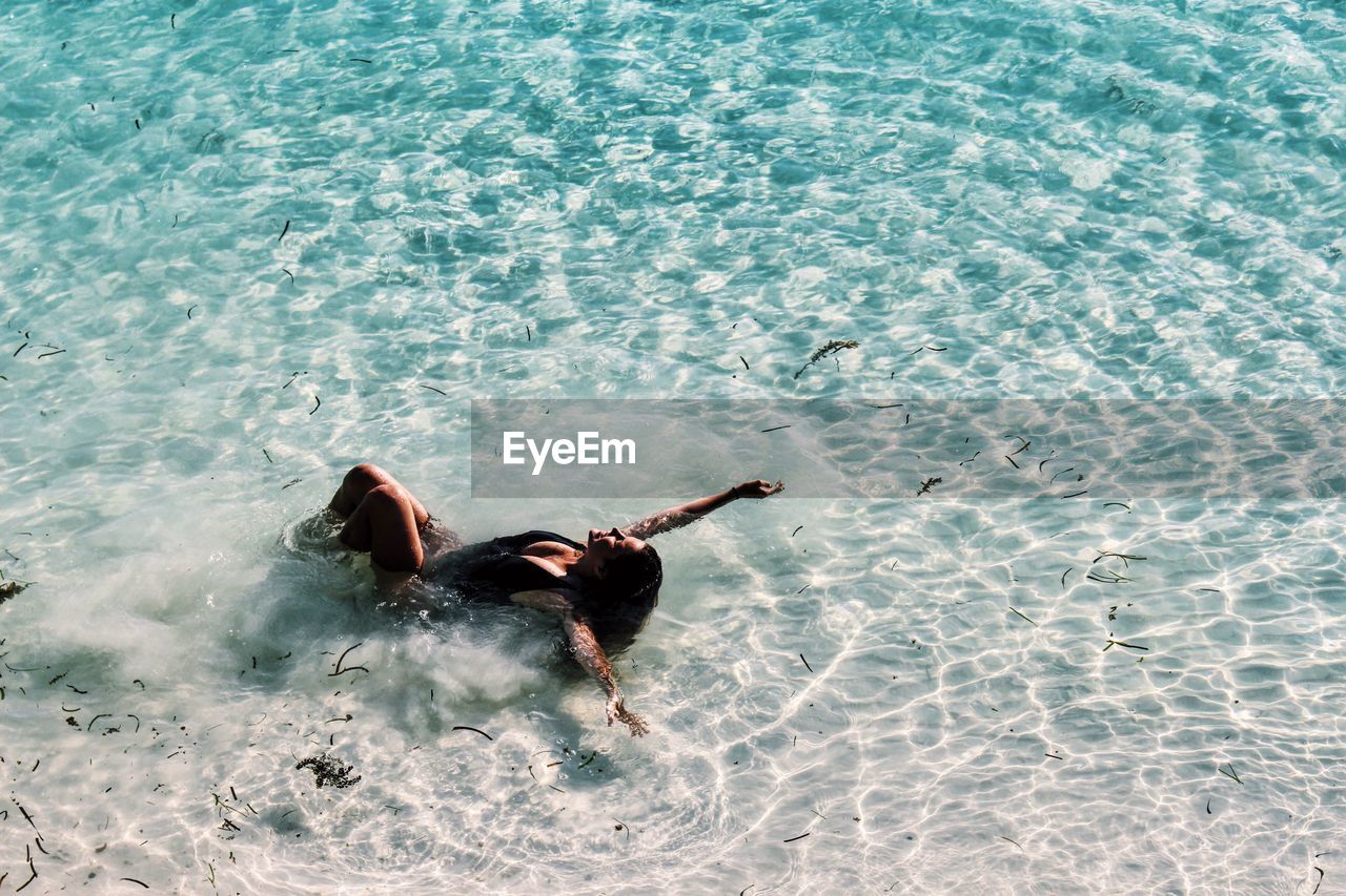 High angle view of young woman swimming in sea