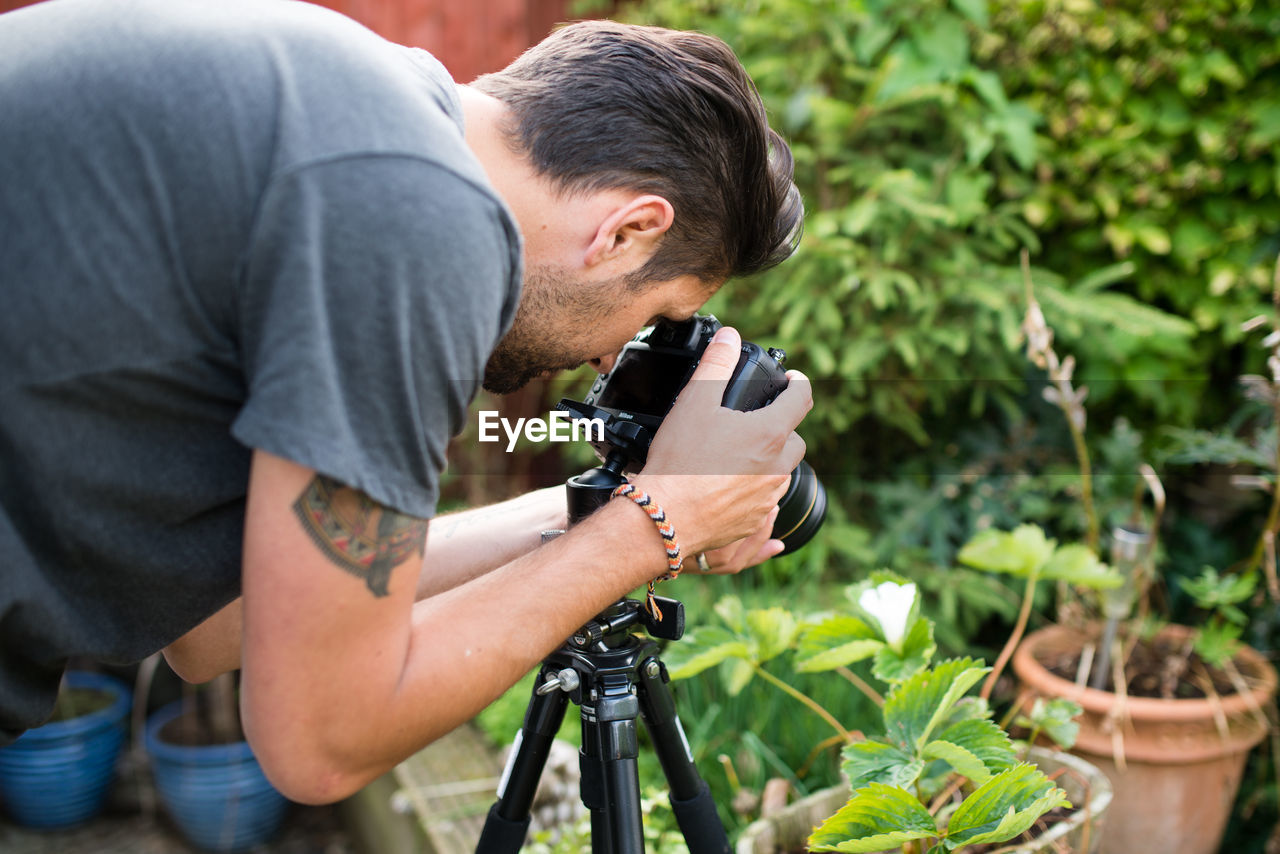 Man photographing potted plant