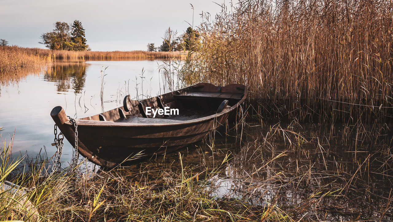 Old oak boat chained to reeds in the swedish archipelago during the autumn