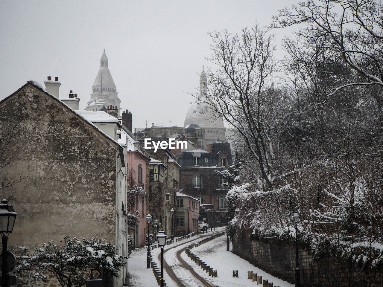 Buildings in city against sky during winter