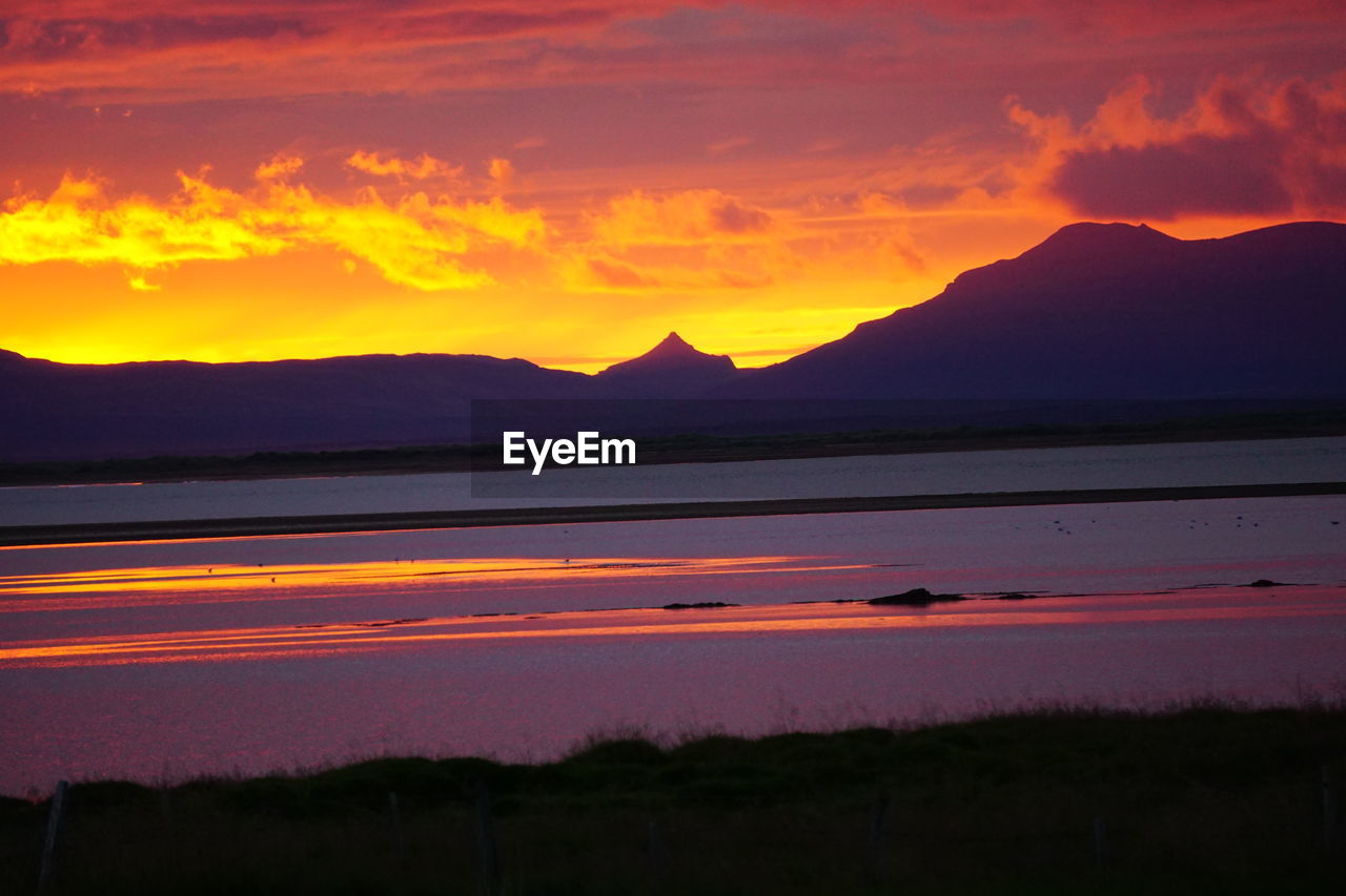 SCENIC VIEW OF SILHOUETTE MOUNTAIN AGAINST ORANGE SKY