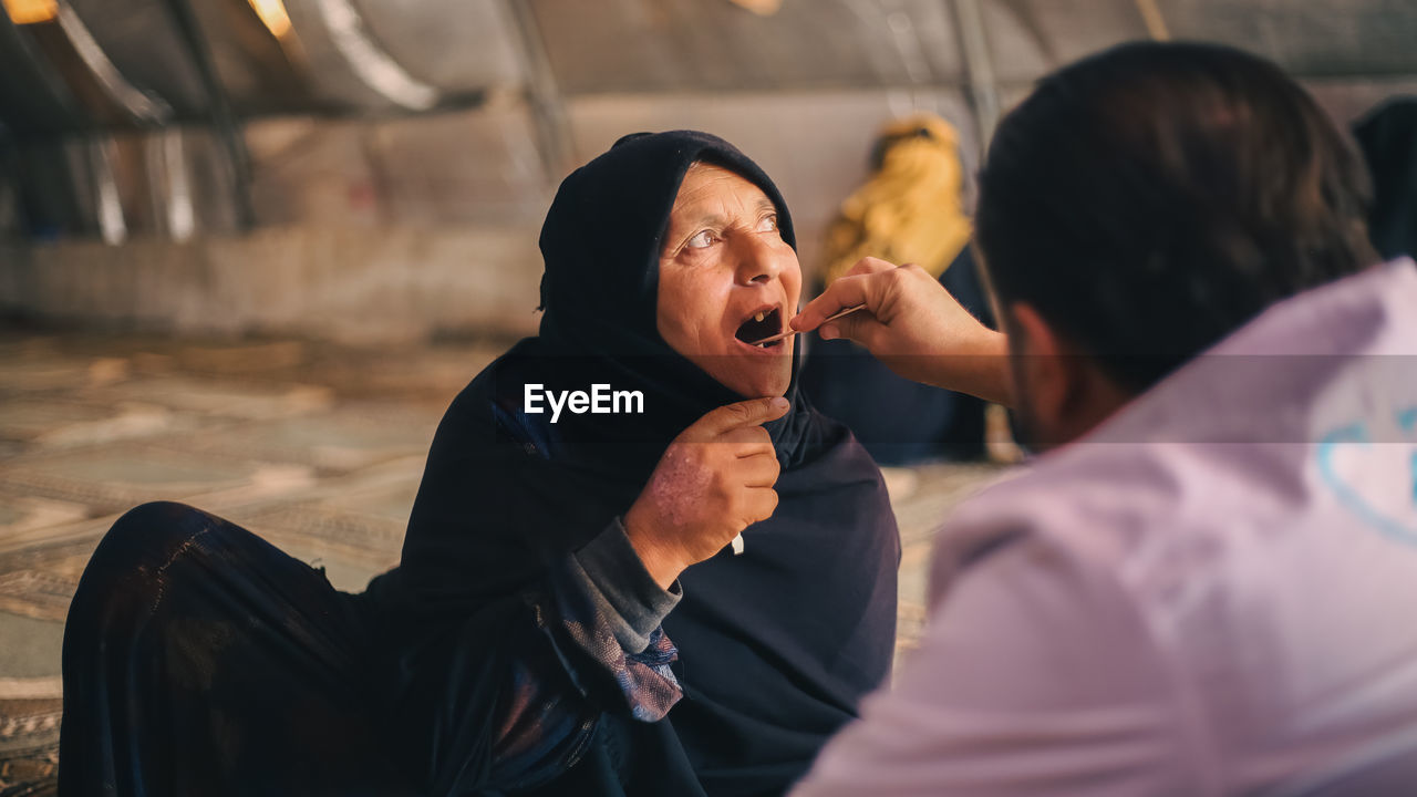 An elderly woman receives medical care at a makeshift medical clinic inside a syrian refugee camp.