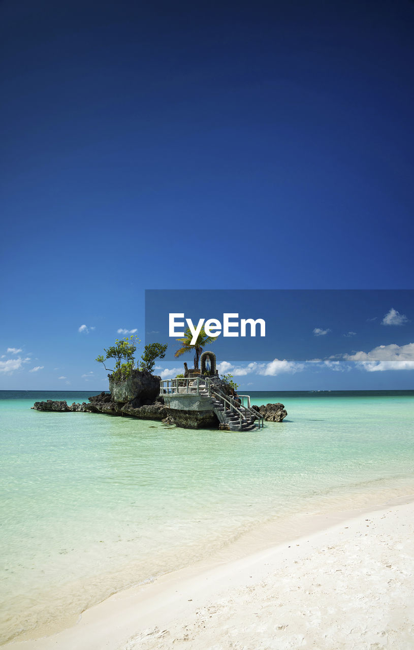 Chapel in sea against blue sky