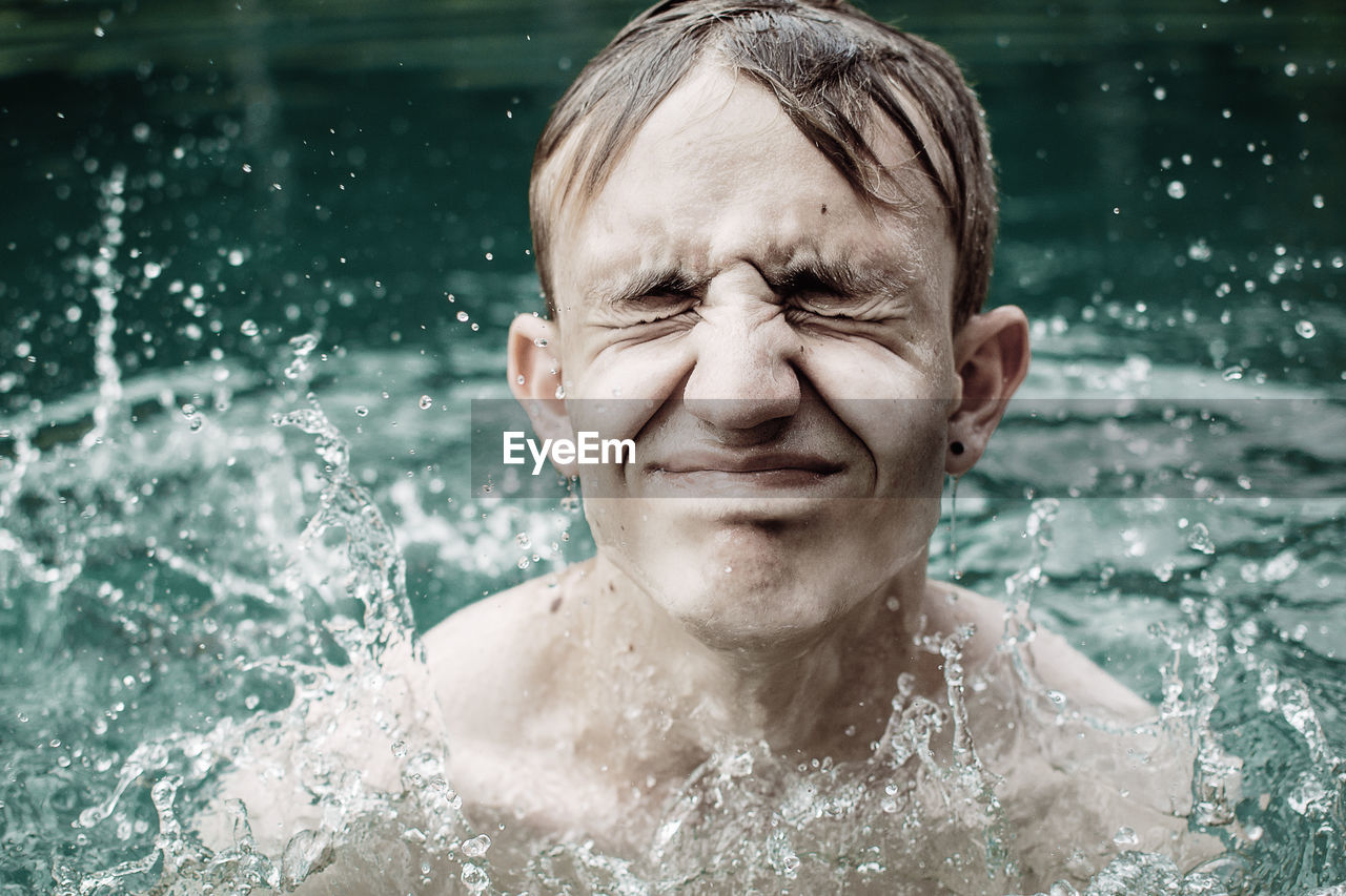 Close-up of teenage boy with eyes closed in swimming pool