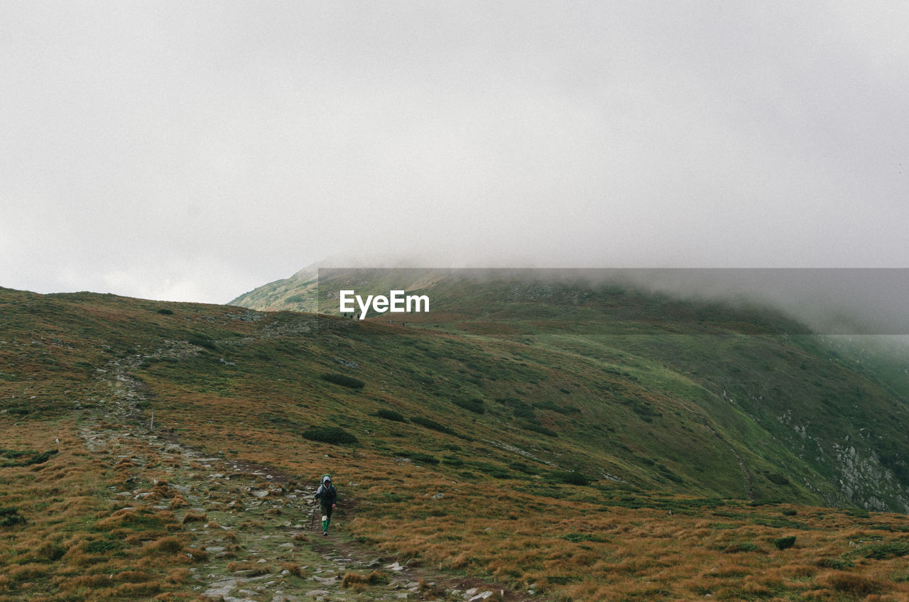 Man hiking on mountain during foggy weather
