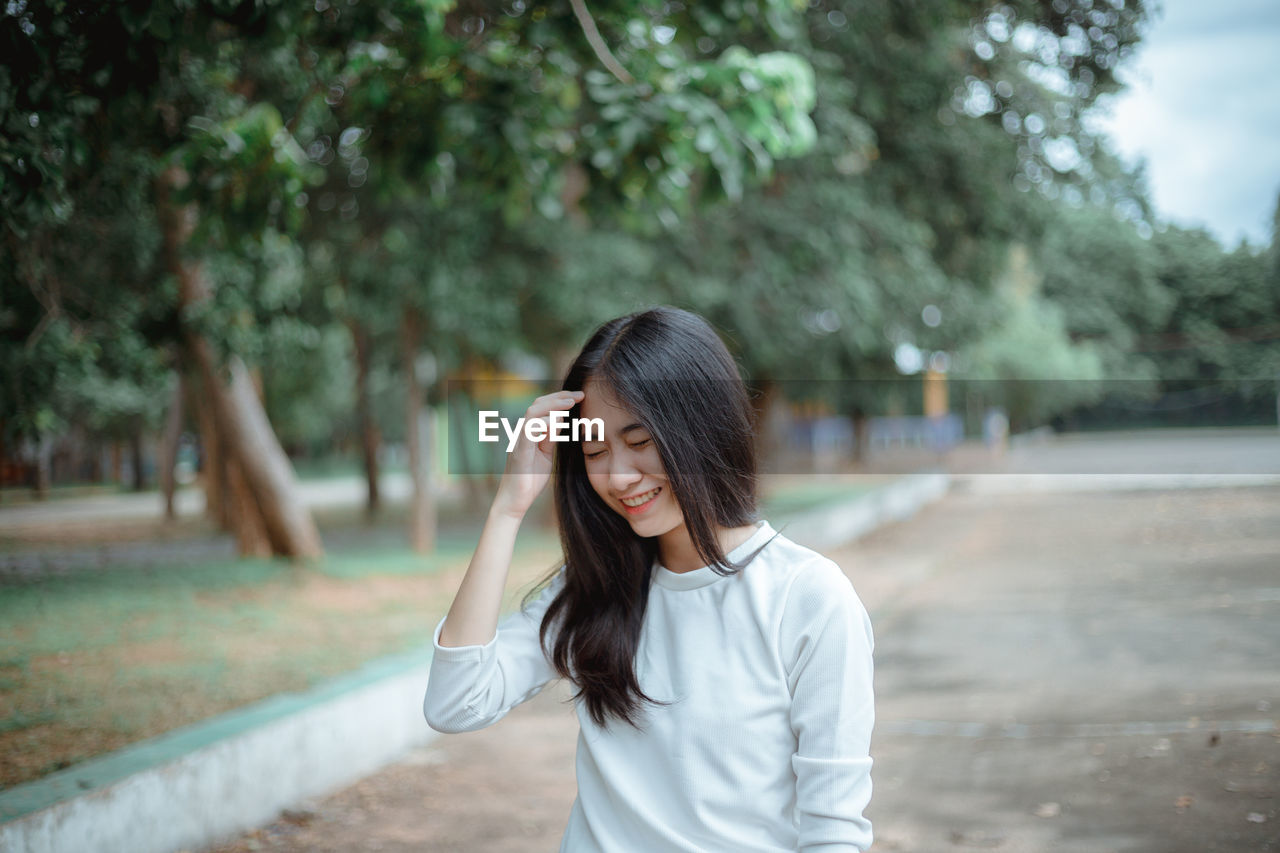 Smiling young woman standing outdoors