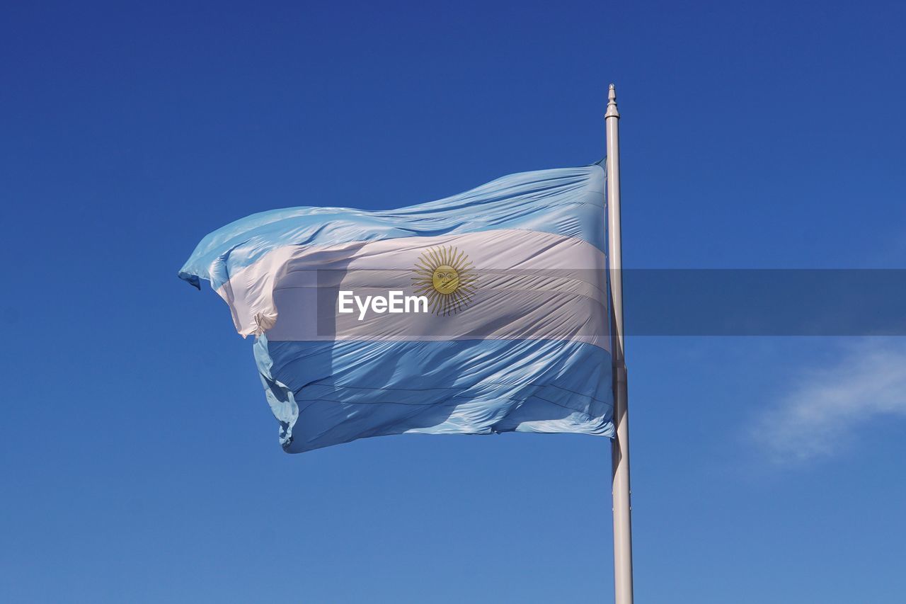 Low angle view of an argentinian flag against blue sky