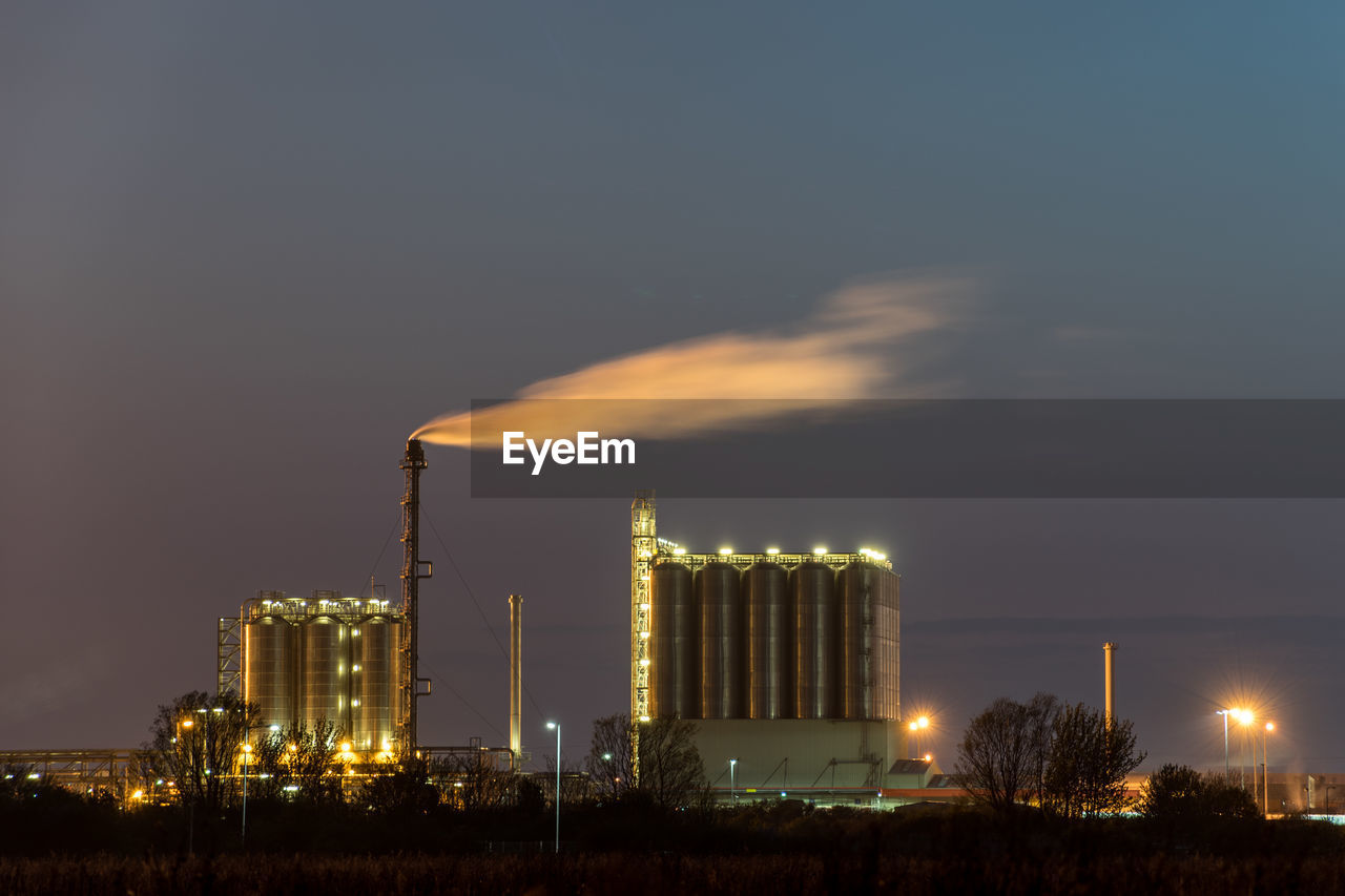 Smoke emitting from factory against sky at night